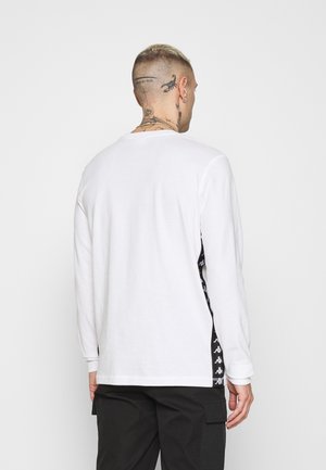 Langärmliges weißes T-Shirt mit einem schwarzen gemusterten Seitenpanel, Rundhalsausschnitt und lässiger Passform. Aus Baumwolle, im casual Design.