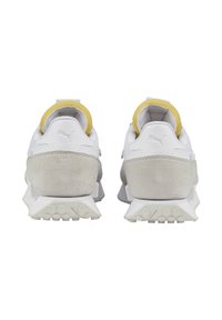 White sneakers with yellow accents and grey suede details. Features a textured sole and padded collar for comfort. Logo on heel.