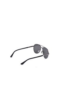 Lunettes de soleil aviateur noires avec verres foncés et monture en métal fine, vues en trois quarts arrière sur fond blanc.