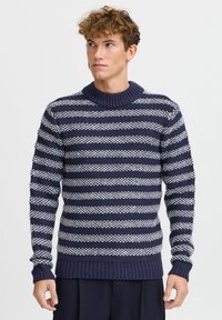 Maglione a righe navy e bianco realizzato in maglia, con colletto e polsini a coste, caratterizzato da un motivo testurizzato di righe spesse e sottili alternate.