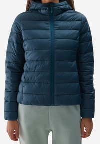 Granatowa kurtka puchowa z kapturem, z pikowanym wzorem, przednim zamkiem błyskawicznym i elastycznymi mankietami. Materiał ma gładkie, błyszczące wykończenie.