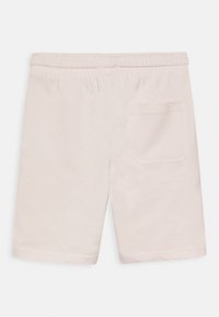 Calças curtas de algodão bege claro com cós elástico e um único bolso traseiro, apresentando uma textura suave e um design até aos joelhos.