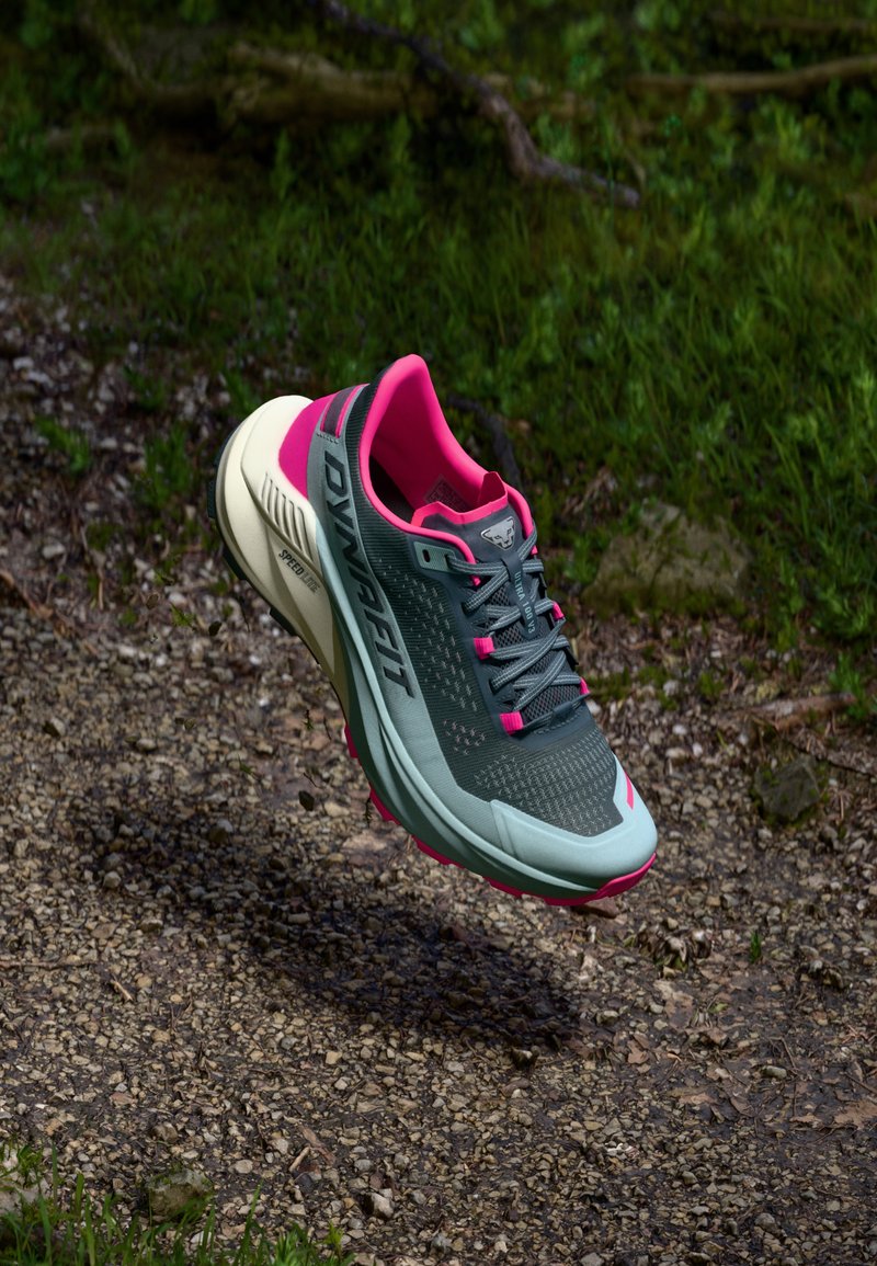 Šedá a tyrkysová športová obuv s ružovými akcentmi. Sieťovinový zvršok, odpružená podrážka a vzorované detaily. Ľahká konštrukcia pre vonkajšie použitie.