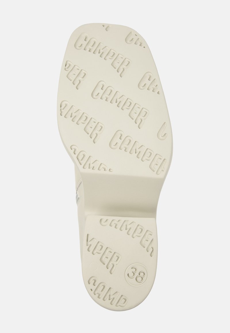 Sula av en sko i krämfärg med mönstrad "CAMPER"-logotyp. Har en lätt klack och rund tå, märkt med storlek 38.