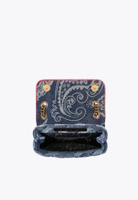 Borsa in denim con motivo paisley, rifiniture rosse, hardware dorato e un interno con fodera loggata nera. Si apre con due chiusure a scatto.