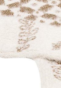 Biely pletený materiál so zlatými metalickými niťami, s textúrovaným vzorom pripomínajúcim listy a malými ozdobami vytvárajúcimi jemný, detailný design.