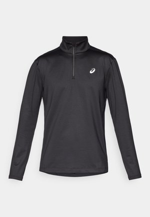 T-shirt de sport noir à manches longues avec un col montant zippé. Ses caractéristiques incluent un design épuré, un tissu évacuant l'humidité et un petit logo en accent.