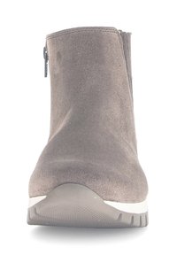 Bottines en suede gris avec un bout rond, détails de fermeture éclair sur le côté, et une semelle en caoutchouc avec des motifs de grip texturés.