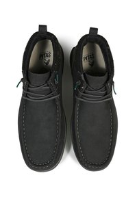 Zapatos de ante negro con punta redonda y costuras blancas. Presentan un interior suave y detalles en verde en los cordones.