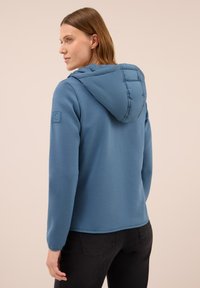 Blauwe hooded sweatshirt met een textuurkap, lange mouwen en een logopatch op de linkerschouder. Glad materiaal en een comfortabele pasvorm.