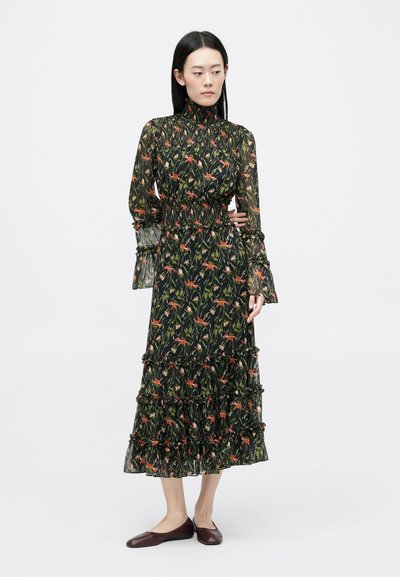 Garš melns kleita ar ziedu rakstu sarkanā un zaļā krāsā. Iezīmē augstu kaklu, savelkamu jostasvietu un slāņveida ruffles uz piedurknēm un apakšmalu. Matēti apavi.