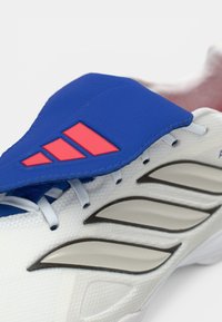 Ελαφριά αθλητικά παπούτσια με λευκή βάση από δίχτυ, μπλε συνθετική επικάλυψη, ροζ λεπτομέρειες και χαρακτηριστικές γκρι ρίγες για υποστήριξη.