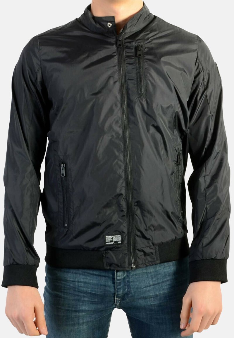 Sort bomberjakke lavet af let, skinnende materiale. Har lynlåslukning foran, to sidelommer og strikkede manchetter. Syning med label ved kanten.