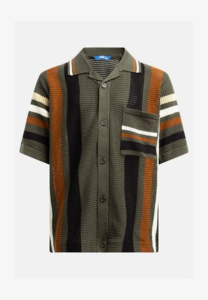 Roheline ja must lühikeste varrukatega särk kudumistekstuuriga, millel on vertikaalsed triibud oranži, valge ja halli värviga. Sellel on rinnatasku ja nööbid.