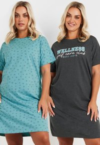Due abiti da donna: uno azzurro chiaro con motivi a stella e uno grigio scuro con il testo "WELLNESS self care club", entrambi casual e dal taglio comodo.