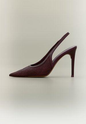 Chaussure slingback à talon haut pointu violet foncé avec texture en dentelle florale et talon stiletto fin sur fond clair uni.