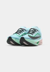 Scarpe da corsa di colore azzurro chiaro con un upper testurizzato, dettagli neri e una suola ammortizzata. Presentano un logo verde e accenti rosa sul tallone.