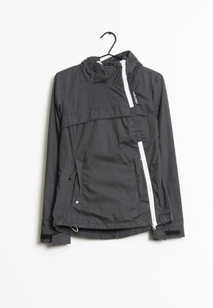 Lekka czarna kurtka z kapturem, z zamkiem błyskawicznym z przodu i dwoma bocznymi kieszeniami. Posiada gładką fakturę oraz regulowany dół.