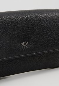 Portafoglio in pelle nera con trama, con piccolo emblema argentato a forma di cuore con ali al centro della patta frontale.