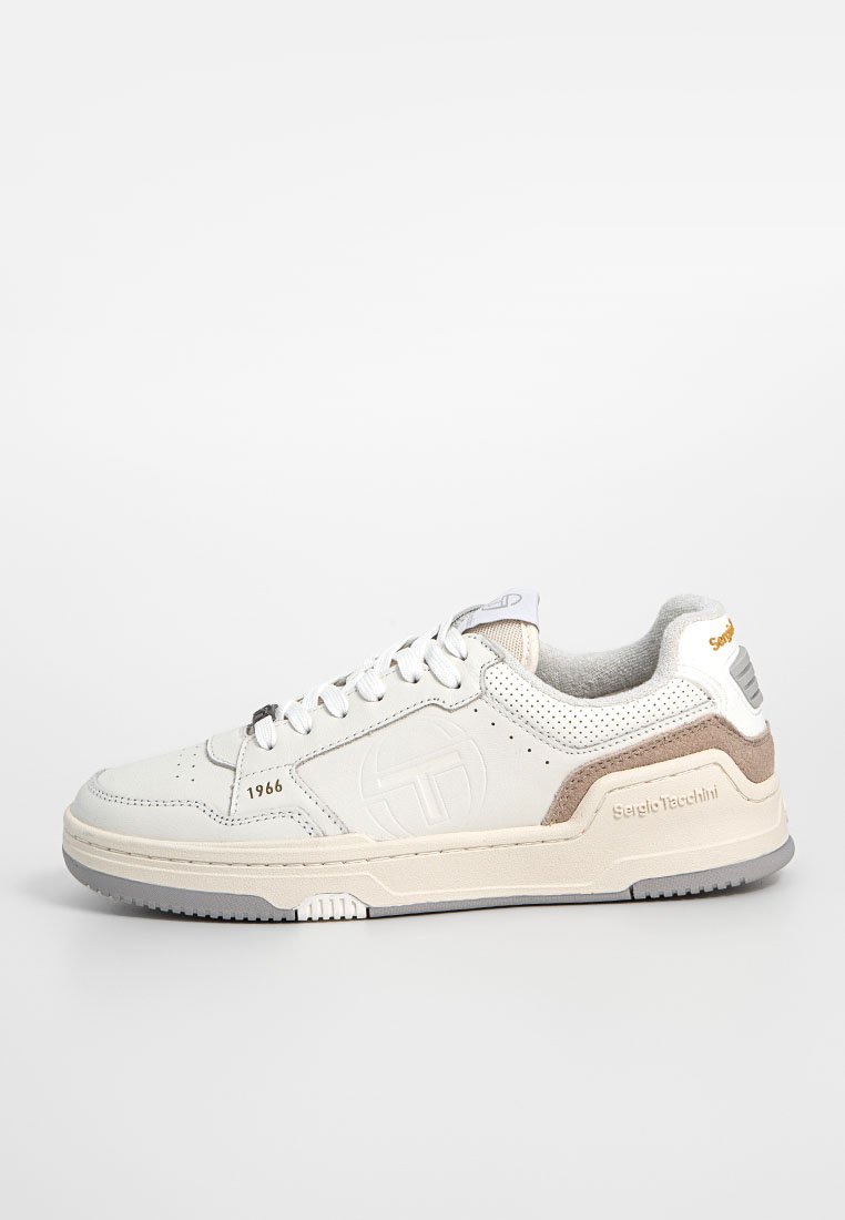 Sneaker bianca in pelle con accenti grigi e beige, pannelli laterali forati, punta rotonda, lacci piatti e dettaglio del logo impresso.