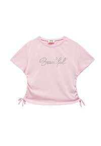 Camiseta de manga corta de color rosa claro, con un diseño fruncido y cordones en los laterales, y el texto metálico "Beautiful" en el frente.