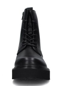 Stivale alla caviglia in pelle nera con lacci, superficie liscia, punta arrotondata e suola in gomma spessa. Dettaglio con zip sul lato.