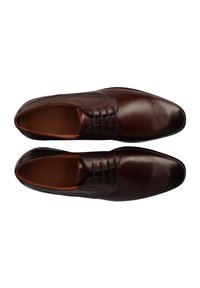 Chaussures habillées en cuir brun foncé avec une finition lisse, dotées d'un design à lacets et de détails perforés près de la languette.