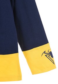 Navy- und gelbes Langarmshirt mit einem gelben Band am Saum und einem schwarzen Spinnenlogo auf dem Arm. Aus Baumwolle gefertigt.
