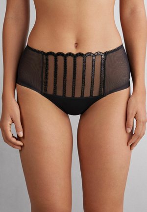 Culotte taille haute noire avec des panneaux en maille transparente, ornée de dentelle festonnée et d'accents en dentelle verticale à l'avant pour plus de détails.