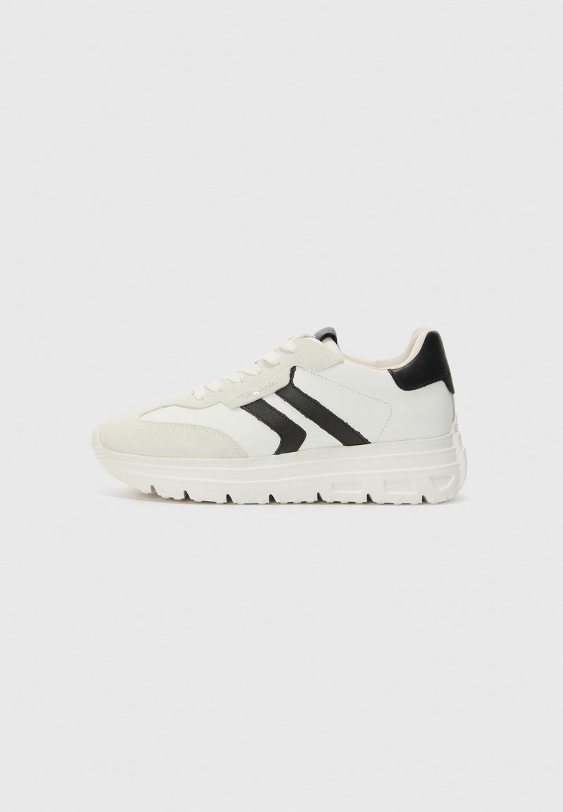 Hvite sneakers med svarte detaljer, laget av en kombinasjon av lær og semsket skinn, med rund tå og en teksturert gummisåle.