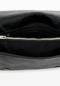 Clutch bag in pelle nera texturizzata con chiusura a zip, dotata di una fodera interna liscia e di una tasca con zip aggiuntiva all'interno.