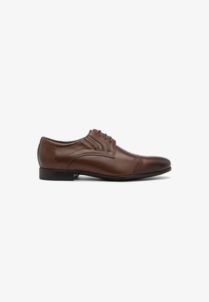 Scarpa da cerimonia in pelle marrone con una finitura liscia, design con lacci, punta rotonda e tacco nero basso. Dettagli di cucitura vicino ai lacci.