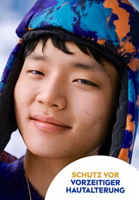 Bunte, gepolsterte Kapuze mit einem blau-orange-schwarzen Muster. Nahaufnahme eines Gesichts, das glatte Haut und einen entspannten Ausdruck zeigt.