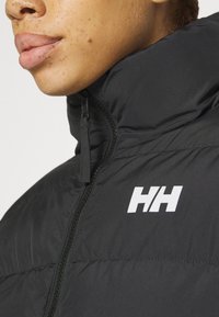 Black puffer jacket with a high collar, featuring a central zipper and white "HH" logo on the side. Smooth, matte texture.
