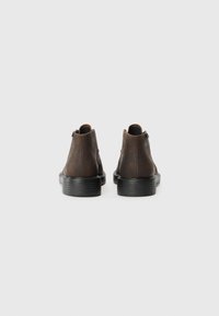 Brown leather ankle boots with a smooth finish, rounded toe, and black rubber soles. Features a subtle seam along the back and side zip closure.