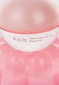 Masque lèvres au collagène PDRN dans un contenant en gelée rose, avec un dessus arrondi et un texte de marque en relief sur une surface brillante.