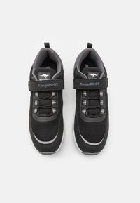 Schwarze Sportschuhe aus Mesh und synthetischen Materialien mit gepolstertem Kragen, verstellbarem Riemen und strukturiertem Gummiaußensohle.