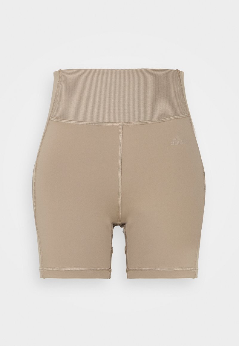 Short de sport beige taille haute avec ceinture côtelée et coutures flatlock, avec un logo Adidas discret sur la cuisse gauche.