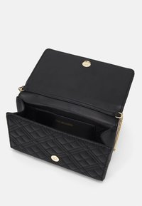 Borsa a tracolla in pelle trapuntata nera con dettagli in oro, caratterizzata da una chiusura a scatto e un design interno con logo impresso. Forma compatta e strutturata.