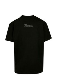 Sort bomulds T-shirt med en afslappet pasform. Bagsiden har hvid tekst i en centreret layout med et citat om kærlighed og frygt.