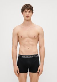 Črne bombažne bokserice s mekim pasom, na katerem je v sivi barvi napis "JACK & JONES". Imajo prilegajoč dizajn in gladko teksturo.