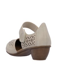 Sandal con tacco in legno basso, realizzata in pelle beige perforata e con cinturino regolabile. Presenta cuciture decorative lungo il bordo.