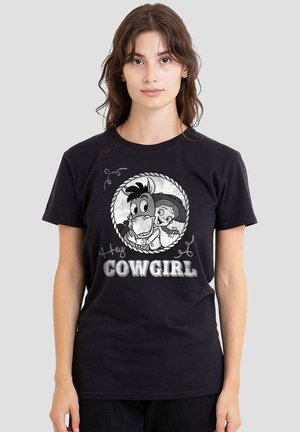 Young woman wearing black t-shirt with cartoon horse and girl inside rope circle and text "Hey Cowgirl" on front.