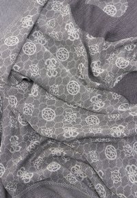 Γκρι ύφασμα με λευκά κυκλικά λουλουδένια σχέδια και λεπτές υφές γραμμές, απεικονιζόμενο με απαλά πέπλα και τσακίσματα.