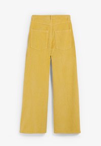 Pantalones de pana amarillos de pierna ancha con textura de rayas verticales, que cuentan con dos bolsillos traseros y una cinturilla recta.