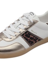Baskets blanches avec accents dorés métalliques, panneau latéral imprimé léopard, lacets blancs et semelle beige, marque Tamaris sur le côté.