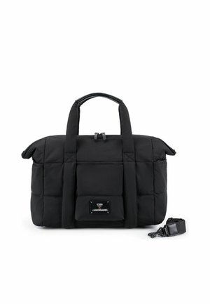 Borsa da viaggio imbottita nera con doppie maniglie, tasca frontale, chiusura con cerniera e tracolla removibile posta accanto su sfondo bianco.