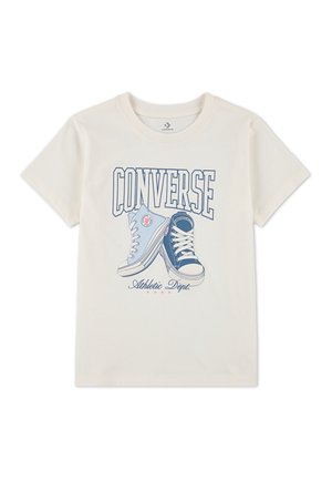 Kremkrāsas T-krekls ar grafiku, kurā attēlotas divas Converse kedas zilās toņos, ar izteiksmīgu tekstu "CONVERSE" virsū un "Athletic Dept." apakšā.