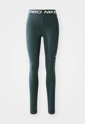 Sötétzöld leggings elasztikus anyagból, széles derékrésszel, amelyen a "PRO NIKE" logo található, és egy kis fehér Nike swoosh az oldalon.