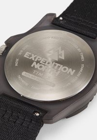 Crni remen s satom od tkanine sa stražnjim dijelom od nehrđajućeg čelika, na kojem se nalazi ugravirani natpis "EXPEDITION NORTH TIMEX". Solarni pogon, vodootporan do 50m.